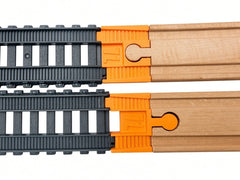 Orange TrainLab adapters between gray plastic track and wooden track, top view
